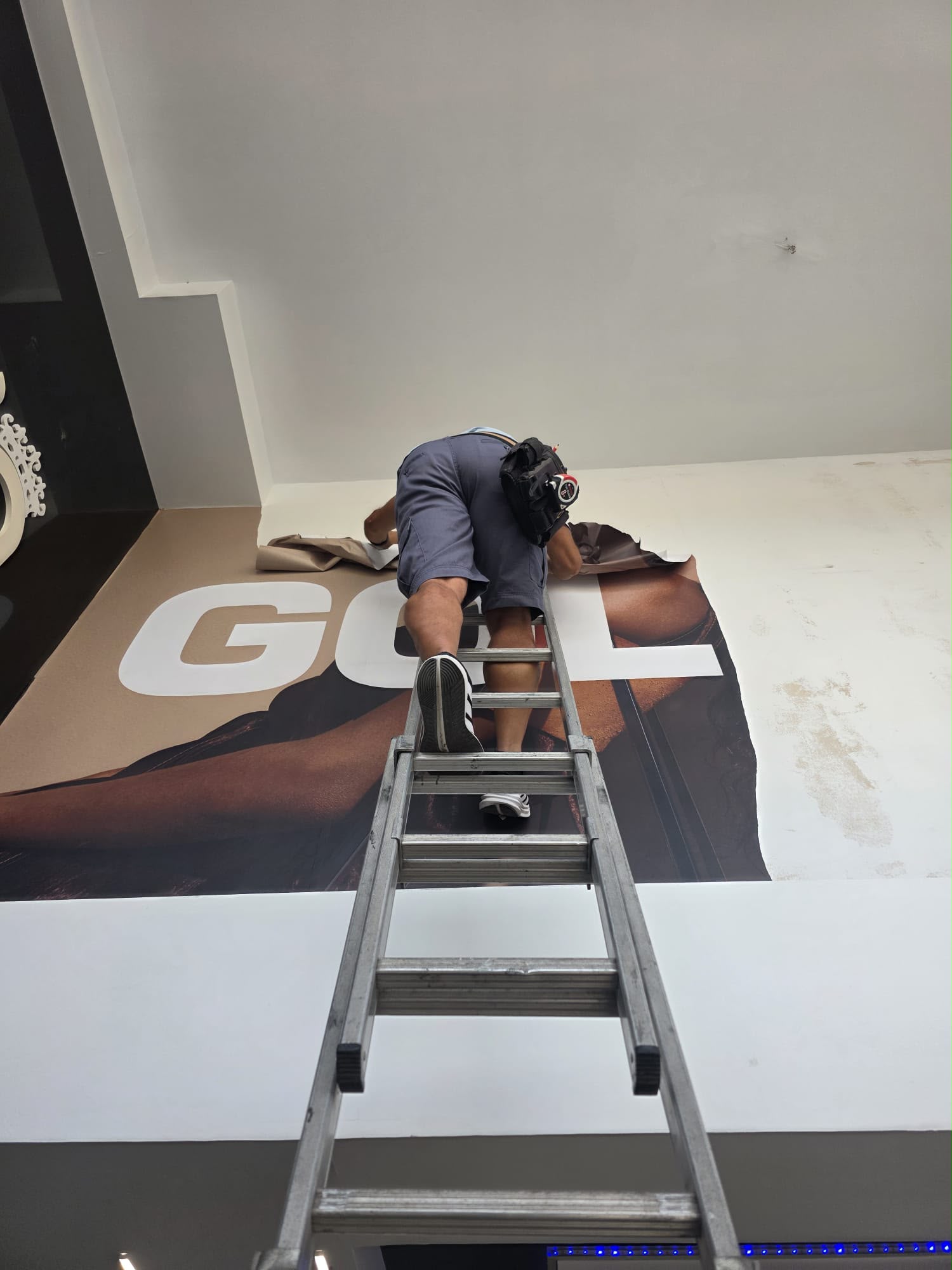 Trabajador colocando la gráfica GOLDWELL sobre la pared