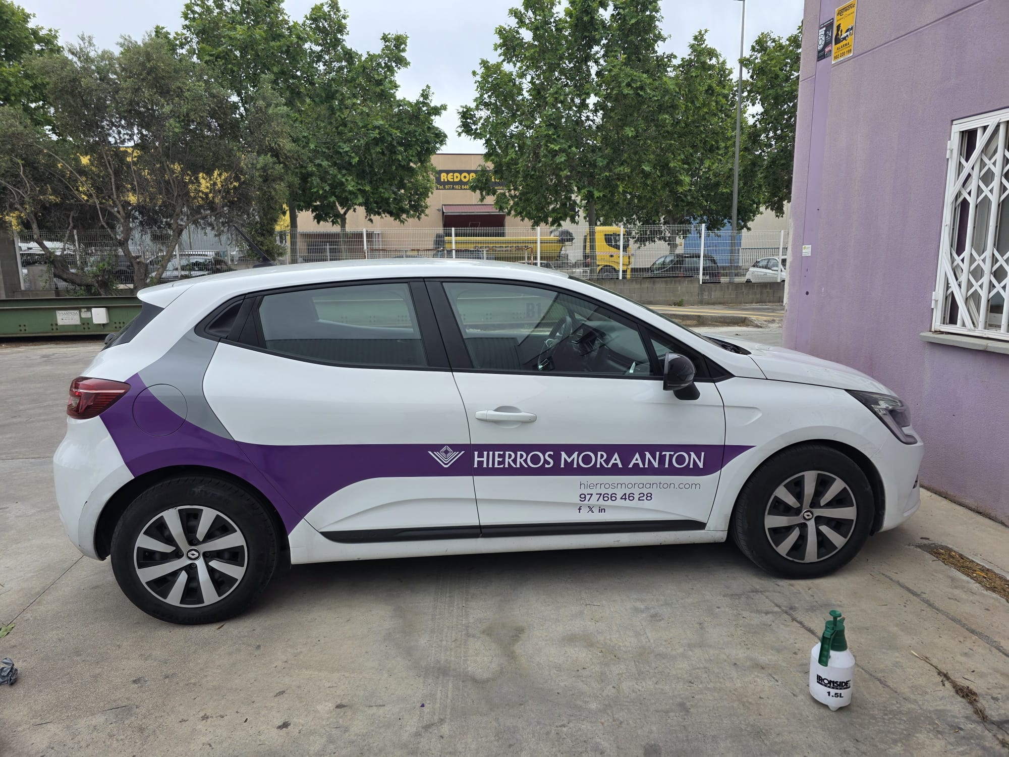 Turismo blanco con gráfica corporativa morada en el lateral