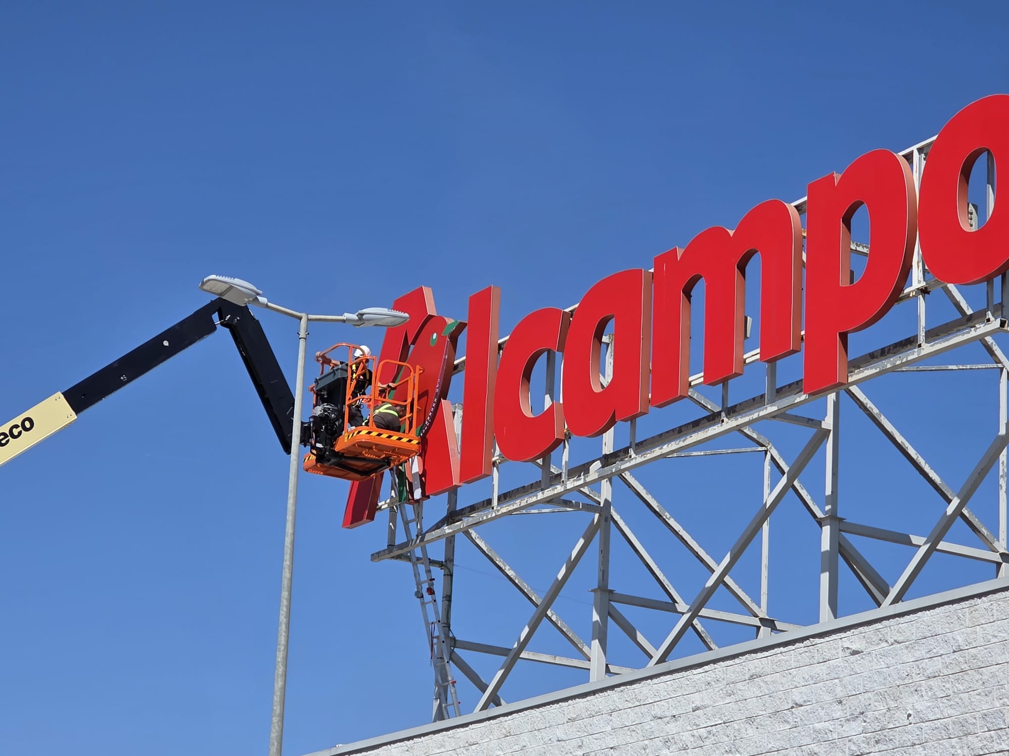 Instalación de letras de Alcampo en una fachada