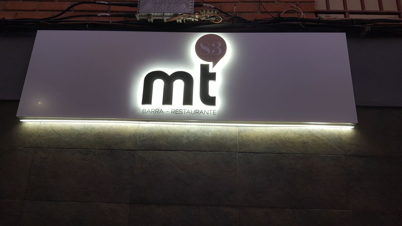 Rótulo iluminado de un bar restaurante sobre la fachada