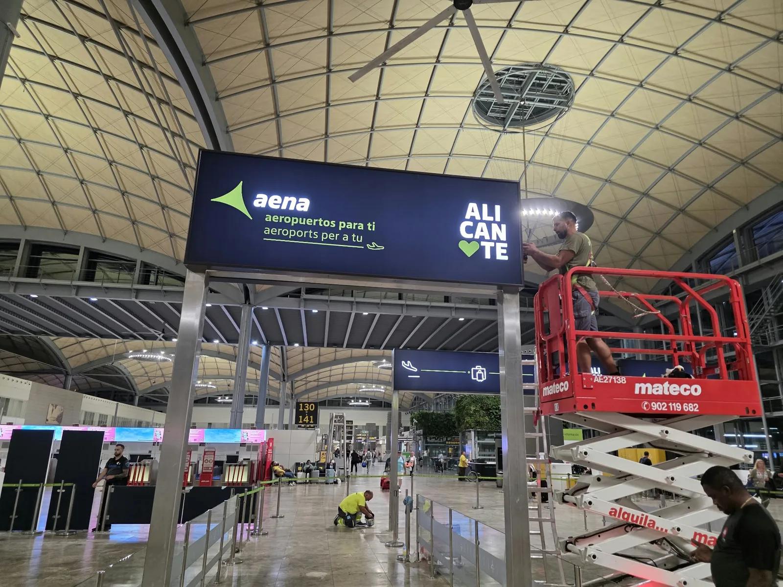 Instalación de un panel de Aena y Alicante con plataforma elevadora en la terminal del aeropuerto