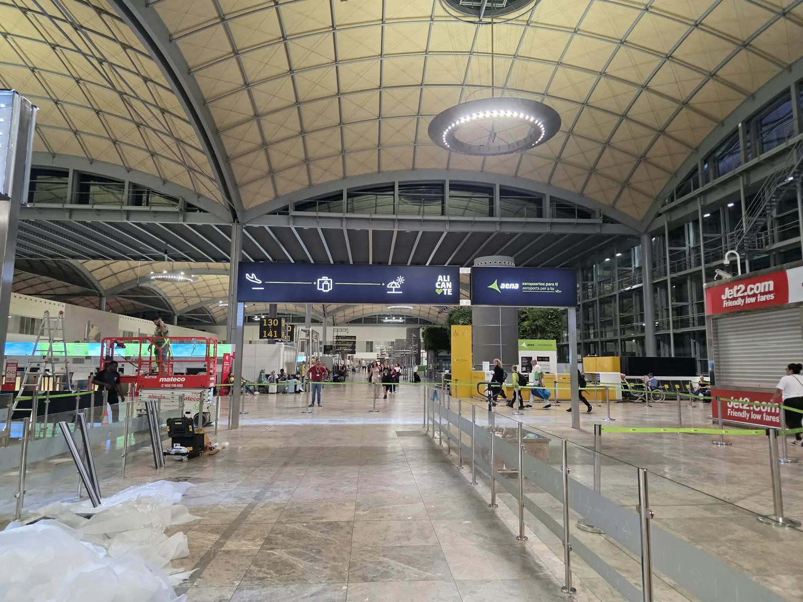 Vista de la terminal con paneles de Aena y Alicante sobre los accesos