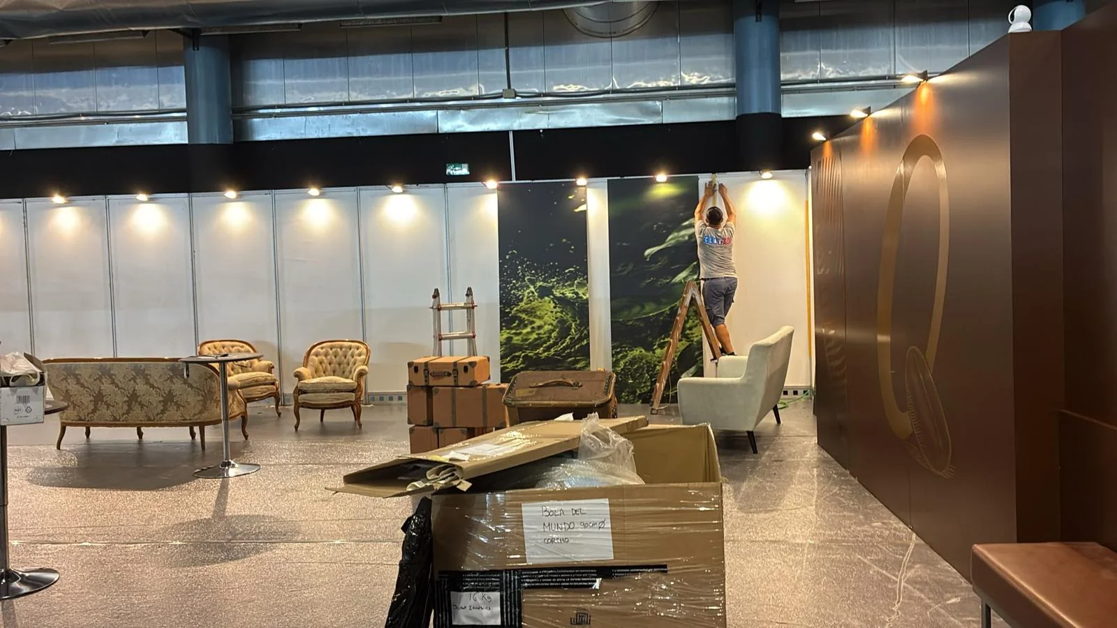 Persona trabajando junto a una pared gráfica del stand