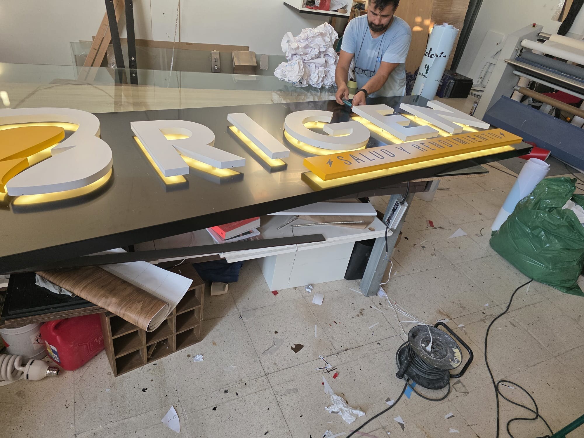 Profesional trabajando en la producción de un rótulo en el taller